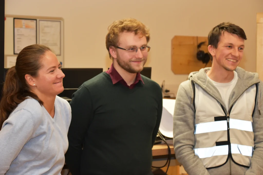 Teilnehmerin und 2 Teilnehmer bei Präsentation nach dem Training gemba.akademie