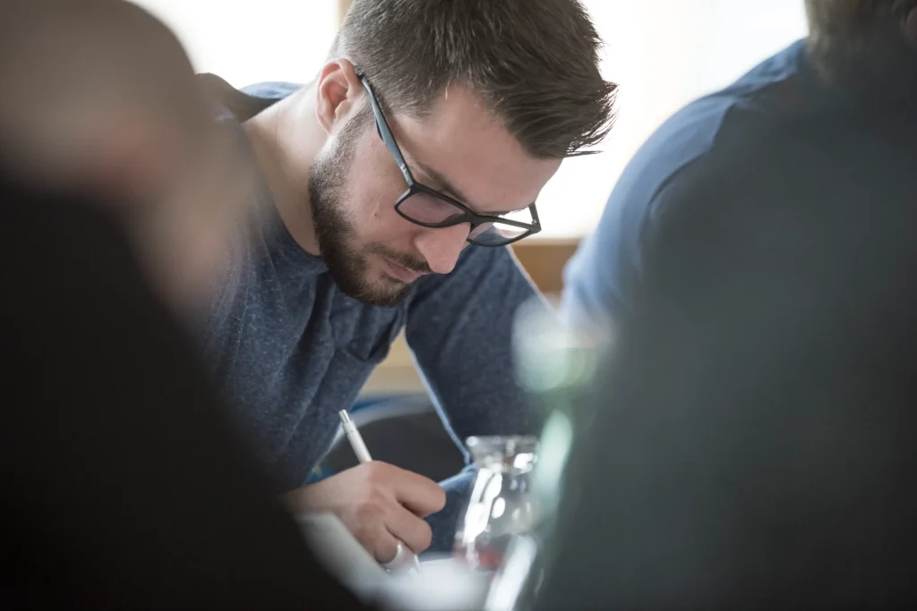 Teilnehmer schreibt etwas auf während gemba.coach Training